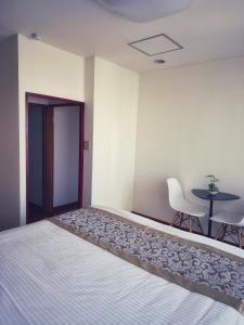 a bedroom with a bed and a table and chairs at Uhome Ueno Hotel in Tokyo +55 photos