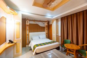 a bedroom with a bed and a table and a chair at LM METRO HOTEL in Zamboanga +35 photos