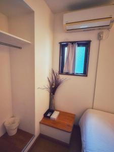 a bedroom with a bed and a table with a book at Uhome Ueno Hotel in Tokyo