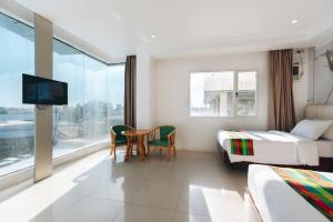 a hotel room with two beds and a table and a tv at LM METRO HOTEL in Zamboanga