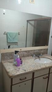 a bathroom counter with a sink and a mirror at Apartamento suite central 72 in Franca
