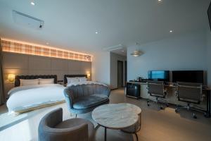 a hotel room with a bed and a table and chairs at Brown Dot Hotel Siheung Geobukseom in Siheung