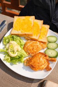 a plate of food with chicken and bread and vegetables at Trang An Lighthouse Homestay in Ninh Binh