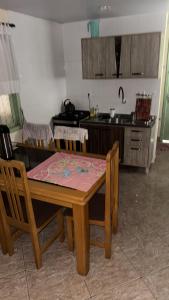 a kitchen with a wooden table and a table and chairs at Casa Zucchi in Itapema