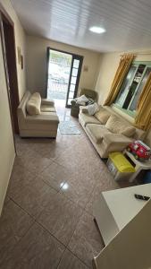 a living room with two couches and a table at Casa Zucchi in Itapema