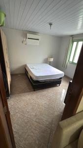 a bedroom with a bed in the corner of a room at Casa Zucchi in Itapema