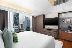 a bedroom with a large white bed and a large window at Hotel Mermaid Bangkok in Bangkok