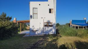 a white building with a door on the side of it at Casa Lavion in Colonia Chapadmalal