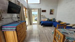 a living room with two beds and a flat screen tv at Casa Lavion in Colonia Chapadmalal