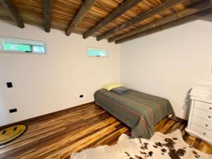 a bedroom with a bed and a wooden floor at WOODEN HOUSE Hermoso alojamiento en Llanogrande Rionegro cerca a Medellín & Aeropuerto JMC in Rionegro