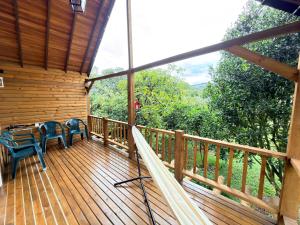 a wooden deck with a table and chairs on it at WOODEN HOUSE Hermoso alojamiento en Llanogrande Rionegro cerca a Medellín & Aeropuerto JMC in Rionegro