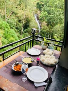a table with plates of food on a balcony at Downtown Lodge in Nuwara Eliya