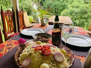 a table with a plate of food and a bottle of wine at Downtown Lodge in Nuwara Eliya +18 photos