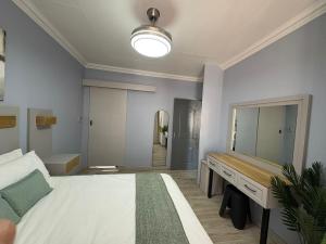 a bedroom with a bed and a desk and a mirror at The Marley in Polokwane