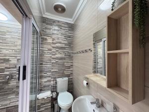 a bathroom with a toilet and a sink and a shower at The Marley in Polokwane