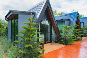 a house with a blue roof and a tree at The View A-Frame Cabin in Chiang Dao