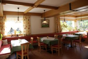 a dining room with tables and chairs and windows at Pension Stammerhof in Schladming