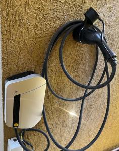 a hose hooked up to a wall with a charger at Duplex premium com garagem perto do centro 5 hósp. in Garanhuns