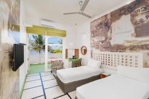 a room with two beds and a balcony at Hotel J Negombo in Negombo