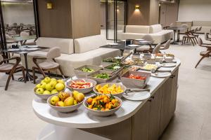 a buffet line with bowls of fruits and vegetables at Mildom Residence in Almaty
