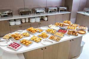 a table filled with different types of pastries at Mildom Residence in Almaty