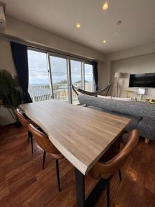 a dining room with a wooden table and chairs at The Villa Lino in Yomitan