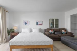 a white bedroom with a bed and a couch at Maho Beach House - Studio - Beach Access in Maho Reef