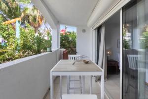 a white dining room with a white table and chairs at Maho Beach House - Studio - Beach Access in Maho Reef