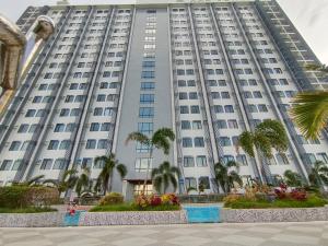 a large white building with palm trees in front of it at Arc Tower Cebu 1714 in Cebu City