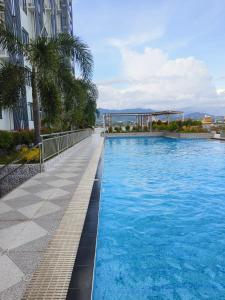 a swimming pool next to a building with palm trees at Arc Tower Cebu 1714 in Cebu City +4 photos