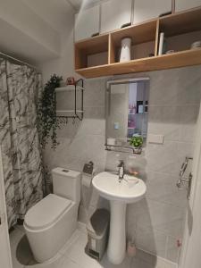 a small bathroom with a toilet and a sink at Arc Tower Cebu 1714 in Cebu City