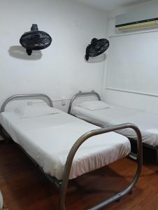 two beds in a hospital room with white walls at Apartamento Victoria B in Ríohacha