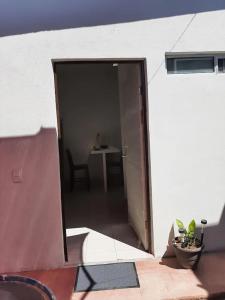 an open door of a white building with a table at Nice apartment in the north in Hermosillo