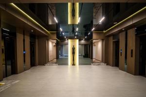 a person walking down a hallway in a building at Mildom Residence in Almaty