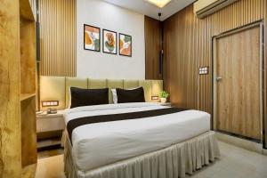 a bedroom with a large bed in a room at OYO Collection O George Town in Colonelganj