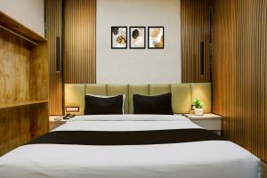 a bedroom with a large white bed in a room at OYO Collection O George Town in Colonelganj +44 photos