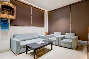 a room with two chairs and a couch and a table at OYO Collection O George Town in Colonelganj