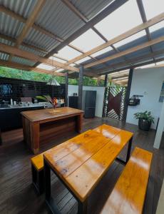 a patio with a wooden table and a bench at Avocado Retreat in Rarotonga