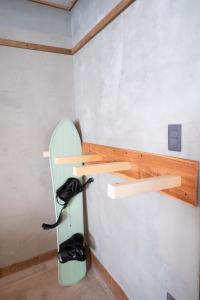 ein Zimmer, in dem ein Surfbrett an der Wand hängt in der Unterkunft ゆらゆら亭 Yura Yura Tei Niseko in Rankoshi
