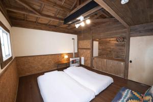 ein Schlafzimmer mit einem weißen Bett in einem Zimmer in der Unterkunft ゆらゆら亭 Yura Yura Tei Niseko in Rankoshi