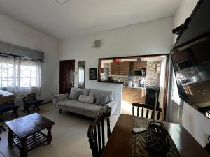 a living room with a couch and a table at Casa independiente con estufa a leña in Minas