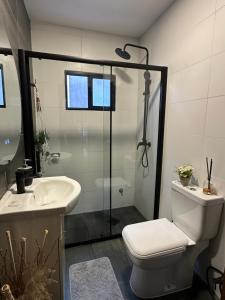 a bathroom with a toilet and a sink and a shower at Casa independiente con estufa a leña in Minas +18 photos