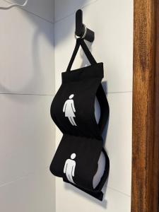 a black bag hanging on a wall with two white towels at Casa independiente con estufa a leña in Minas