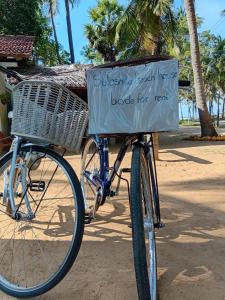 a bike with a basket with a sign on it at Sulashika Beach House in Kandakuli