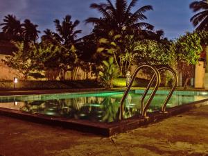 a swimming pool at night with trees and palm trees at The Lagoon Villa in Negombo