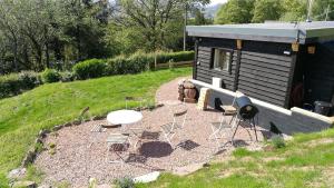 a yard with chairs and a teddy bear and a building at Long Barn Wales in Monmouth