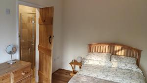 a bedroom with a bed and a walk in shower at Long Barn Wales in Monmouth