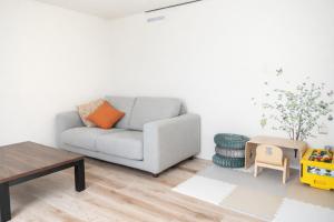 a living room with a couch and a table at The Emu Park Tomiyoshi in Kanie