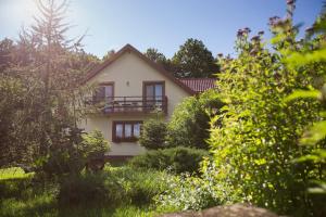 a house in the middle of a garden at Pokoje Gościnne Na Skraju Puszczy in Pogorzelce