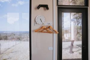 a clock on a wall next to a door at Tallarook Hilltop Tiny House 1 by Tiny Away in Tallarook
